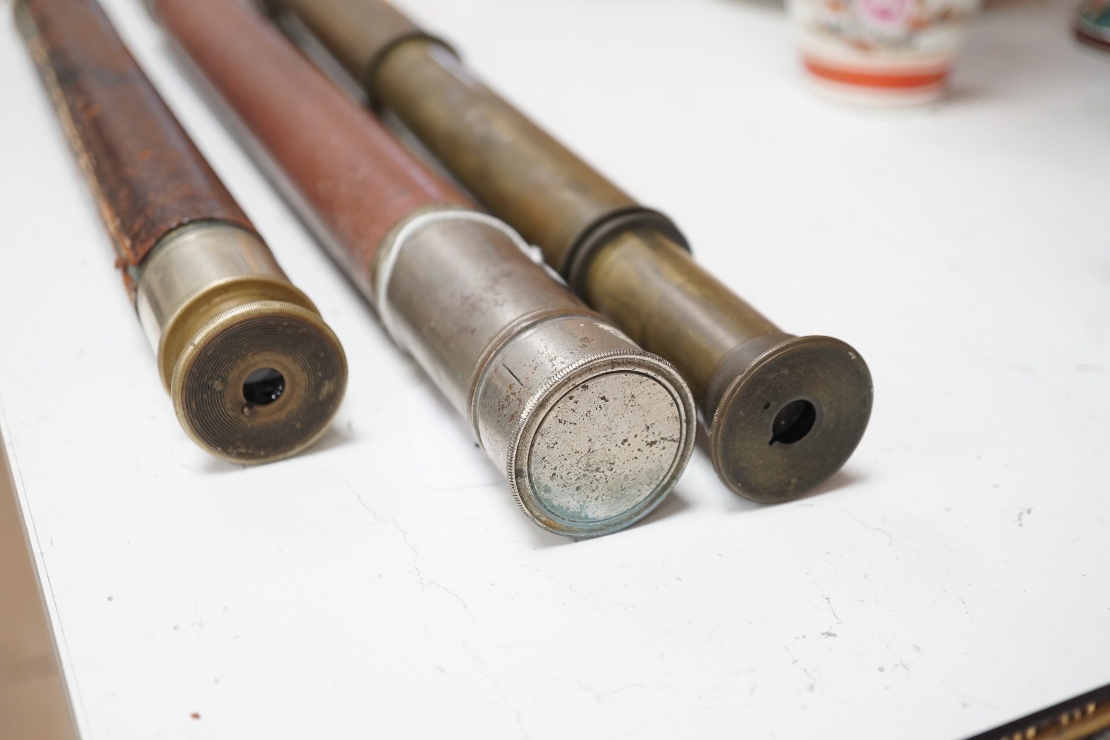 Three leather bound telescopes